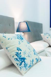 a blue and white pillow on a bed with a lamp at EDIFICIO SUR in Nerja