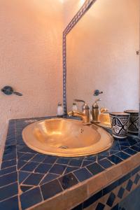 a sink in a bathroom with a mirror at Riad Dar Nawfal in Salé +58 photos