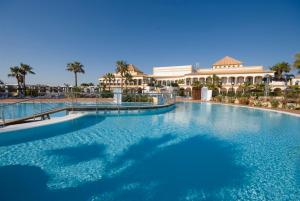 チクラナ・デ・ラ・フロンテーラにあるAldiana Club Andalusienのリゾートの正面に大きなスイミングプールがあります。