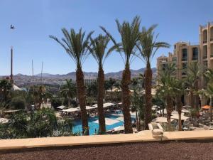a view of a resort with palm trees and a pool at level of 5 star on the beach in Eilat