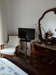 ナザレにあるMar Salgadoのベッドルーム(ドレッサー、テレビ、椅子付)