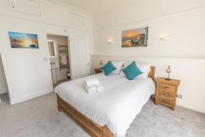 a bedroom with a large white bed with blue pillows at Pier View Apartment in Totland
