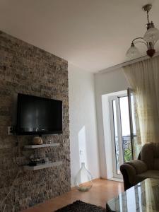 a living room with a television on a brick wall at Guesthouse Maritimo in Ulcinj