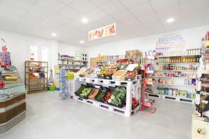 a grocery store aisle with vegetables and other products at Hostel Albergue O Mesón in Puentesampayo