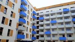 an apartment building with blue windows at Apartament B&F Poznań Business & Family Nałkowskiej in Poznań
