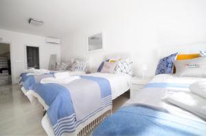 a group of three beds in a room at Violetta in Birżebbuġa