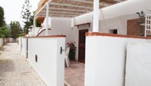 a white house with white walls and a courtyard at Melograno in San Vito lo Capo