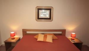 a bedroom with a red bed with two lamps at Melograno in San Vito lo Capo