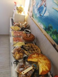 a table filled with different types of bread and pastries at B&B Il Mare degli Dei in Letojanni