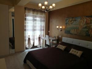 a bedroom with a large bed and a dining room at B&B Il Mare degli Dei in Letojanni