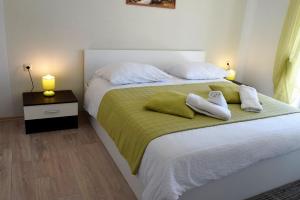 ein Schlafzimmer mit einem Bett mit zwei Kissen darauf in der Unterkunft Apartments Kampor in Rab