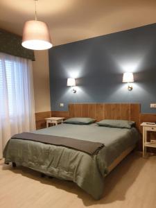 1 dormitorio con 1 cama grande y pared azul en Hotel Il Roscio, en Attigliano