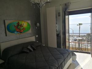 a bedroom with a bed and a view of the ocean at B&B Il Mare degli Dei in Letojanni
