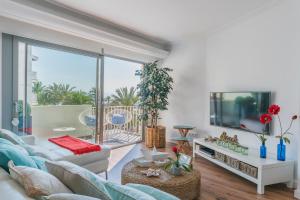 a living room with a couch and a large window at YupiHome Mariners Apartment in Alcudia