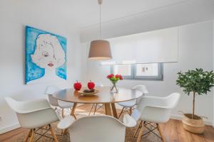 una sala da pranzo con tavolo e sedie bianche di YupiHome Mariners Apartment a Alcudia