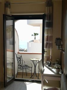 a room with a balcony with a table and chairs at B&B Il Mare degli Dei in Letojanni