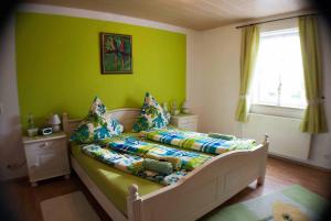 a bedroom with a bed with a green wall at Ferienwohnung Finningen in Finningen