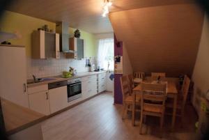 a kitchen with white cabinets and a table and chairs at Ferienwohnung Finningen in Finningen