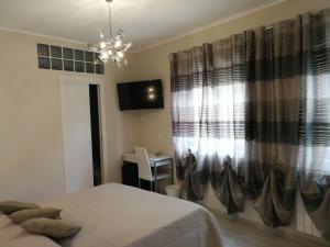 a bedroom with a bed and a window with a desk at B&B Il Mare degli Dei in Letojanni