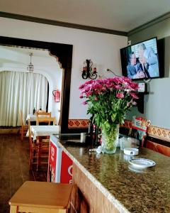 eine Küche mit einer Vase rosa Blumen auf der Theke in der Unterkunft Hospedería Ancladero in Mojácar