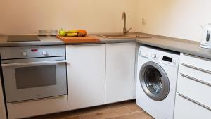 a kitchen with a washing machine and a sink at Rynek Staromiejski Apartment in Koszalin