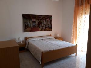 sypialnia z łóżkiem i obrazem na ścianie w obiekcie Lilly w mieście Stignano