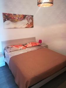 een slaapkamer met een bed en een schilderij aan de muur bij Elegance apartment Taormina in Letojanni
