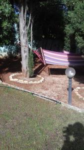 a hammock sitting next to a tree in a yard at Villa Verde Apartments and Rooms in Premantura