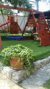 un parque infantil con tobogán y columpio en Villa Verde Apartments and Rooms, en Premantura