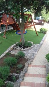 un árbol en un jardín con parque infantil en Villa Verde Apartments and Rooms, en Premantura