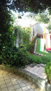 un jardín con parque infantil en un patio en Villa Verde Apartments and Rooms, en Premantura