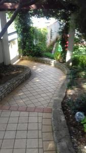 a brick walkway in a yard with a house at Villa Verde Apartments and Rooms in Premantura