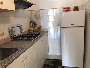 uma cozinha com um frigorífico branco e um fogão em Bambiniello em Anacapri