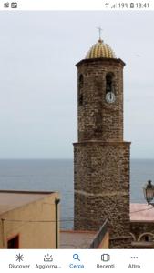 a tall brick tower with a clock on it at L'Antico Faro in Castelsardo