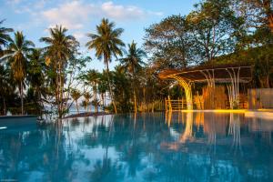 a swimming pool with a gazebo and palm trees at Jaiyen Eco Resort in Ko Yao Noi