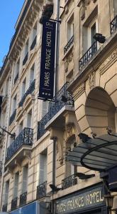 un bâtiment avec un panneau sur son côté dans l'établissement Paris France Hotel, à Paris