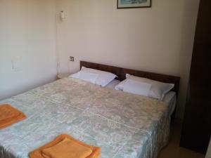 um quarto com uma cama com uma toalha laranja em The House Next to the Beach em Sozopol