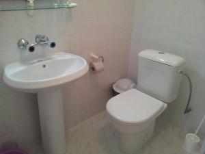 uma casa de banho com um WC branco e um lavatório. em The House Next to the Beach em Sozopol