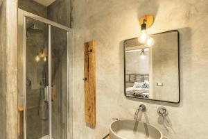 bagno con lavandino, specchio e doccia di B&B I Cinque Mori a Baunei
