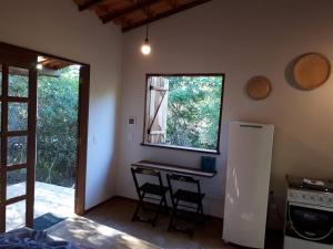 a kitchen with a desk and a window in a room at Chalé da Mangueira in Vale do Capao