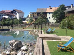 a pool with chairs and a slide in a yard at Gasthaus Sonne in Tarrenz
