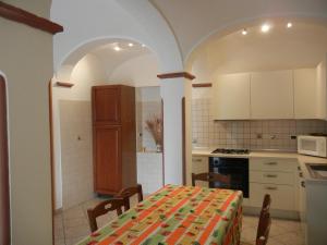 サン・ラッザロ・ディ・サーヴェナにあるcasa vacanza Cicognaのテーブル付きのキッチン、白いキャビネット付きのキッチン