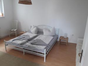 Cama blanca en habitación con suelo de madera en Die alte Stadtmühle direkt an der Flämingskate, en Jüterbog