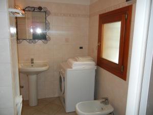 ein Badezimmer mit einem Waschbecken, einem WC und einem Spiegel in der Unterkunft casa vacanza Cicogna in San Lazzaro di Savena