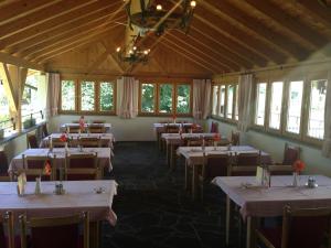 a dining room with tables and chairs and windows at Gasthaus Sonne in Tarrenz