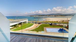 フォスにあるOca Playa de Foz Hotel&Spaのビーチの景色を望むバルコニーが備わる客室です。