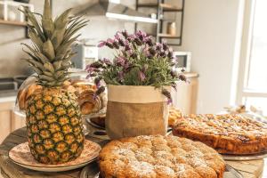 - une table avec des gâteaux, des tartes et un ananas dans l'établissement B&B I Cinque Mori, à Baunei
