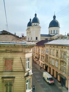 a view of a city with buildings and a van at Romantic Panorama Krakivska street in Lviv