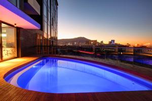 a large swimming pool with a blue sky at Stock Exchange Apartment Hotel in Cape Town