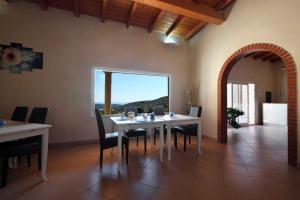 a dining room with a white table and chairs at B&B Raggio di Sole in Fluminimaggiore
